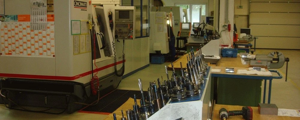 CNC-Fräszentrum mit Werkzeugaufnahmen auf dem Wagen davor